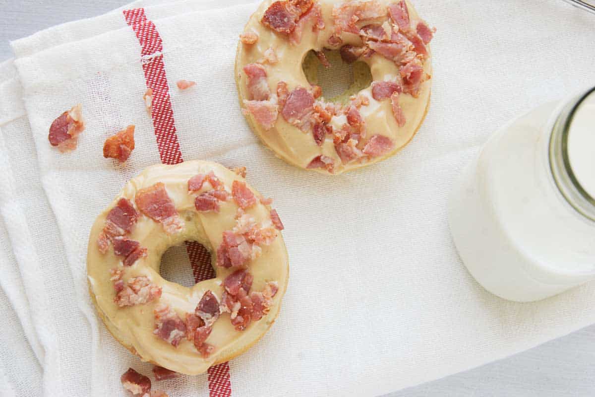 two Banana Baked Donuts with Peanut Butter and Bacon on a towel