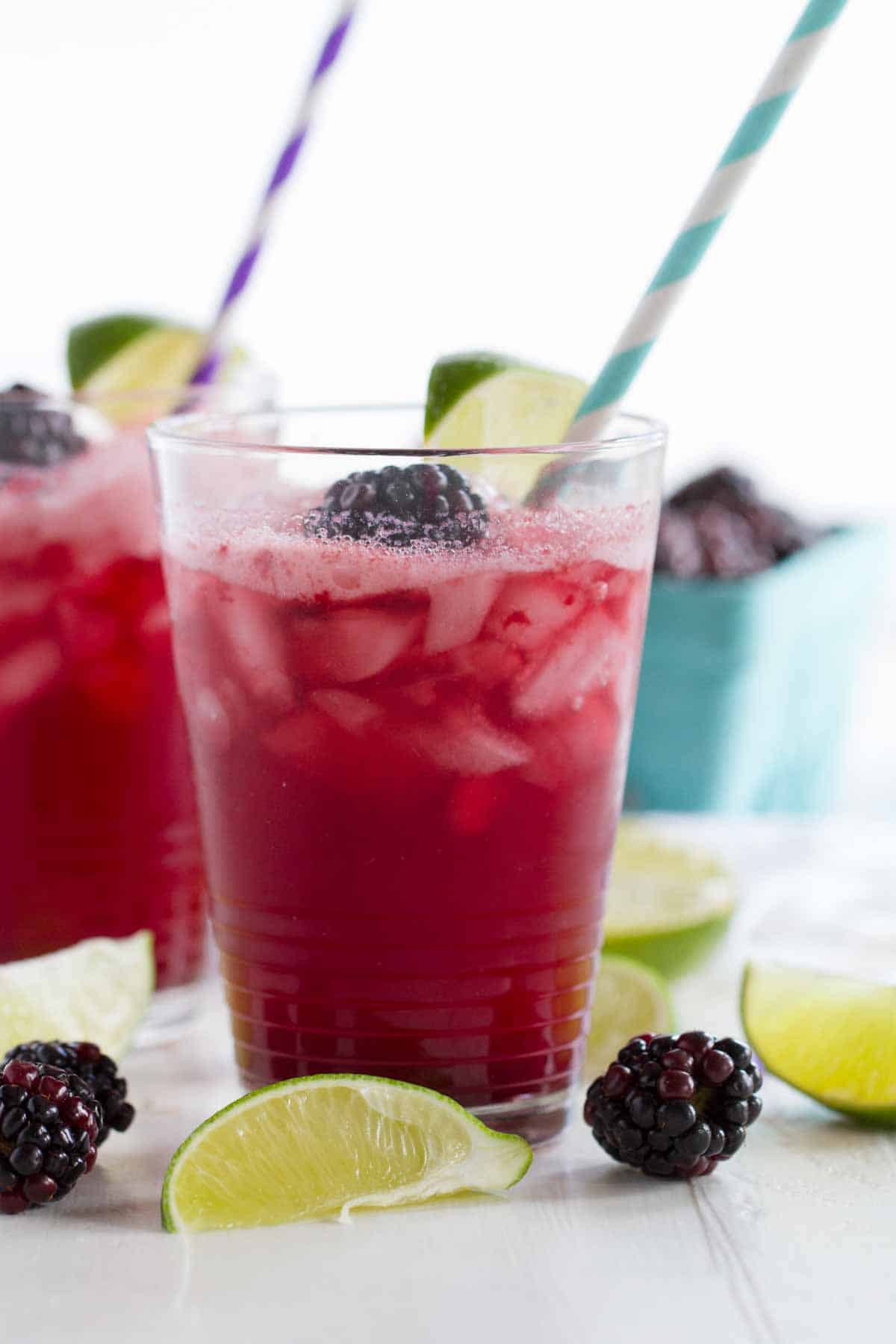 blackberry lime soda in glasses with straws and fresh fruit