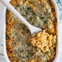 overhead view of a casserole dish of Buffalo Chicken Mac and Cheese with a wooden spoon