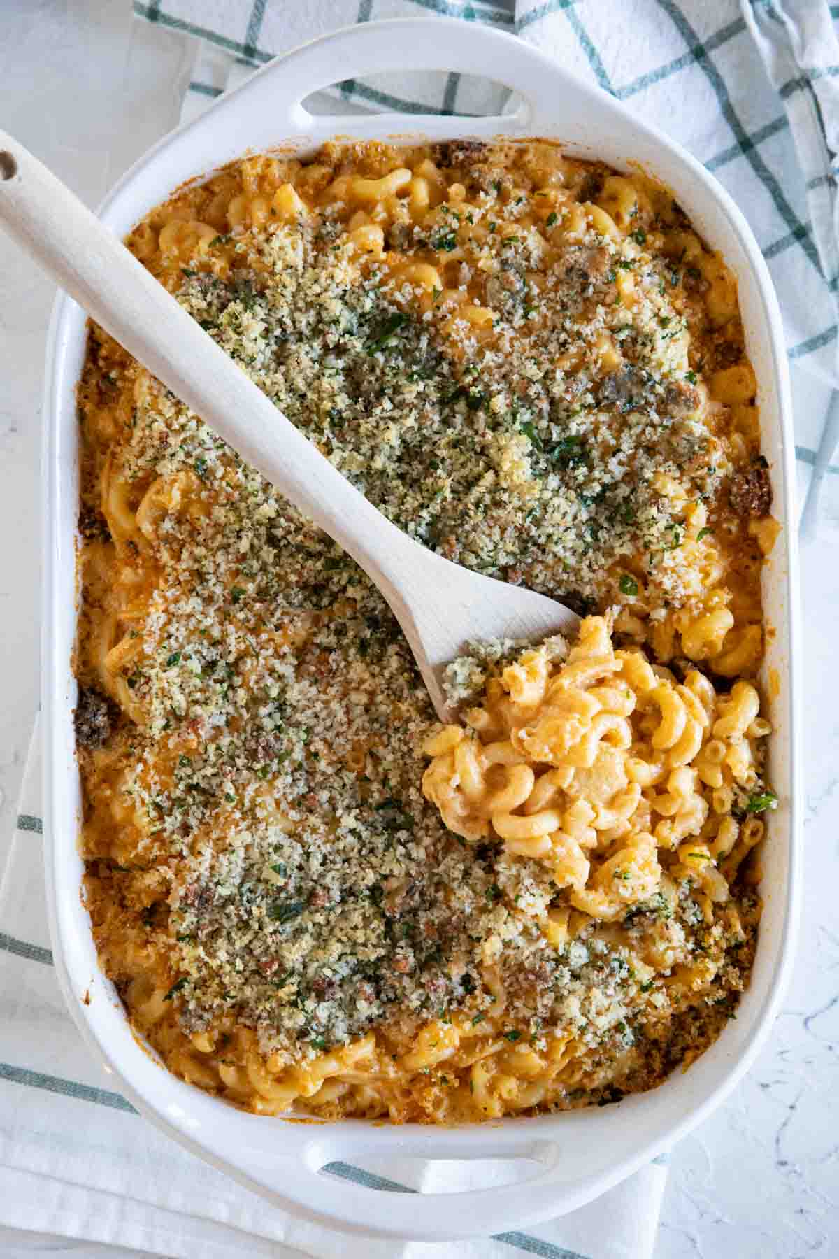 overhead view of a casserole dish of Buffalo Chicken Mac and Cheese with a wooden spoon