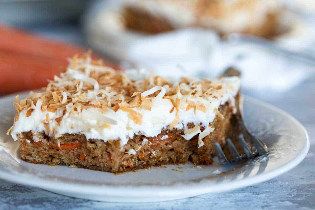 slice of carrot sheet cake with a forkful taken from it