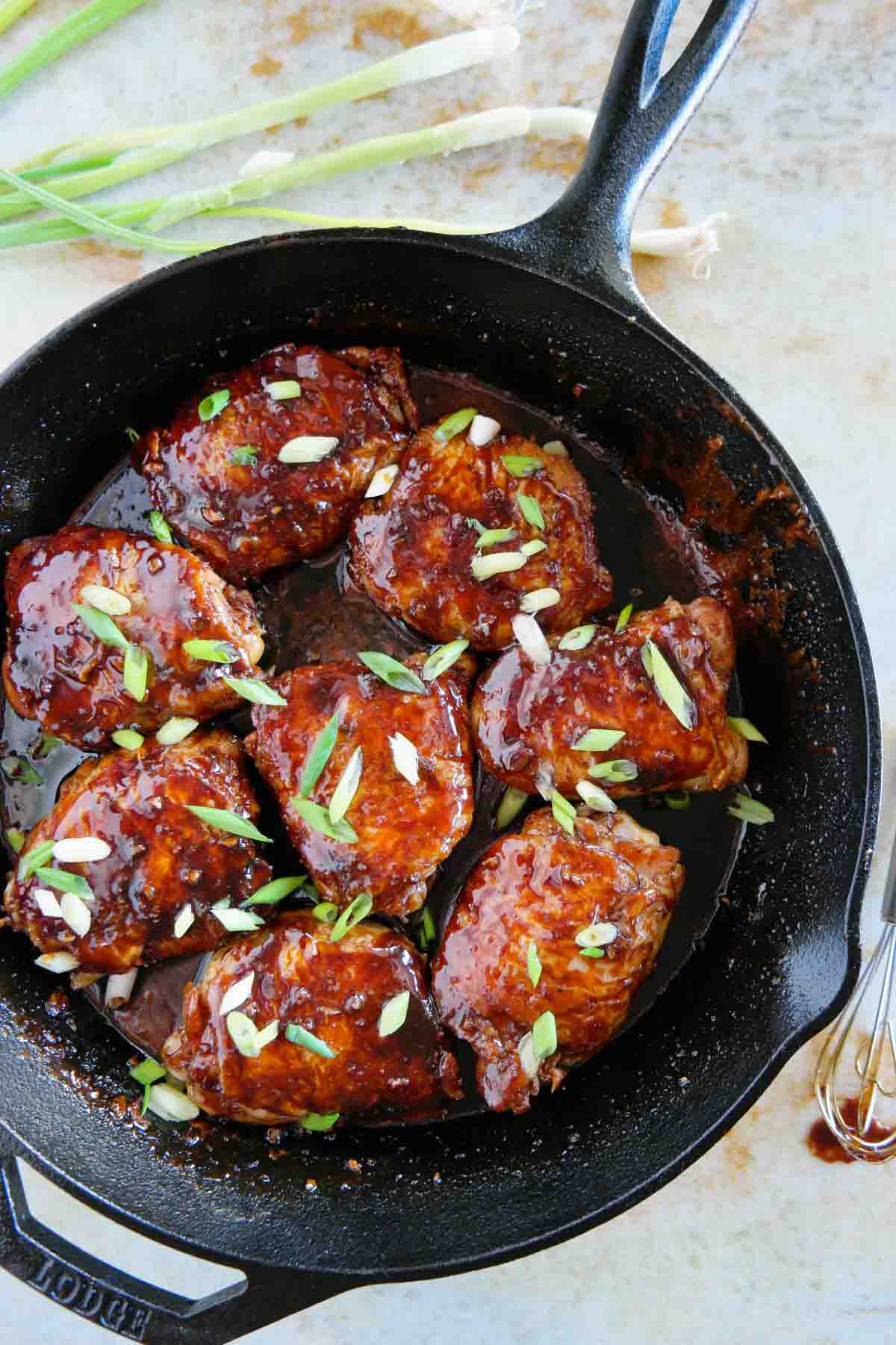overhead view of Cast Iron Chicken Thighs topped with green onions