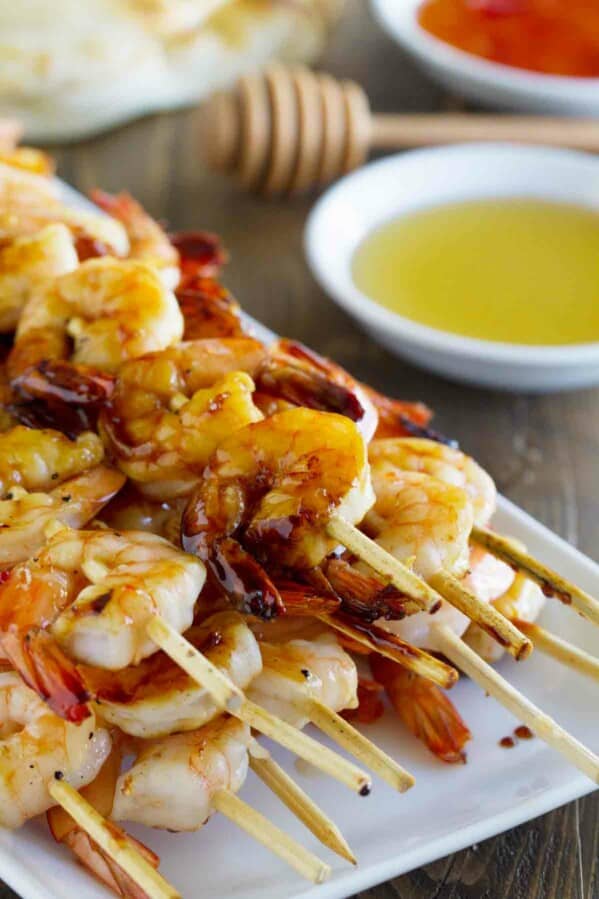 stack of Chili Honey Garlic Shrimp Kabobs with dipping sauces