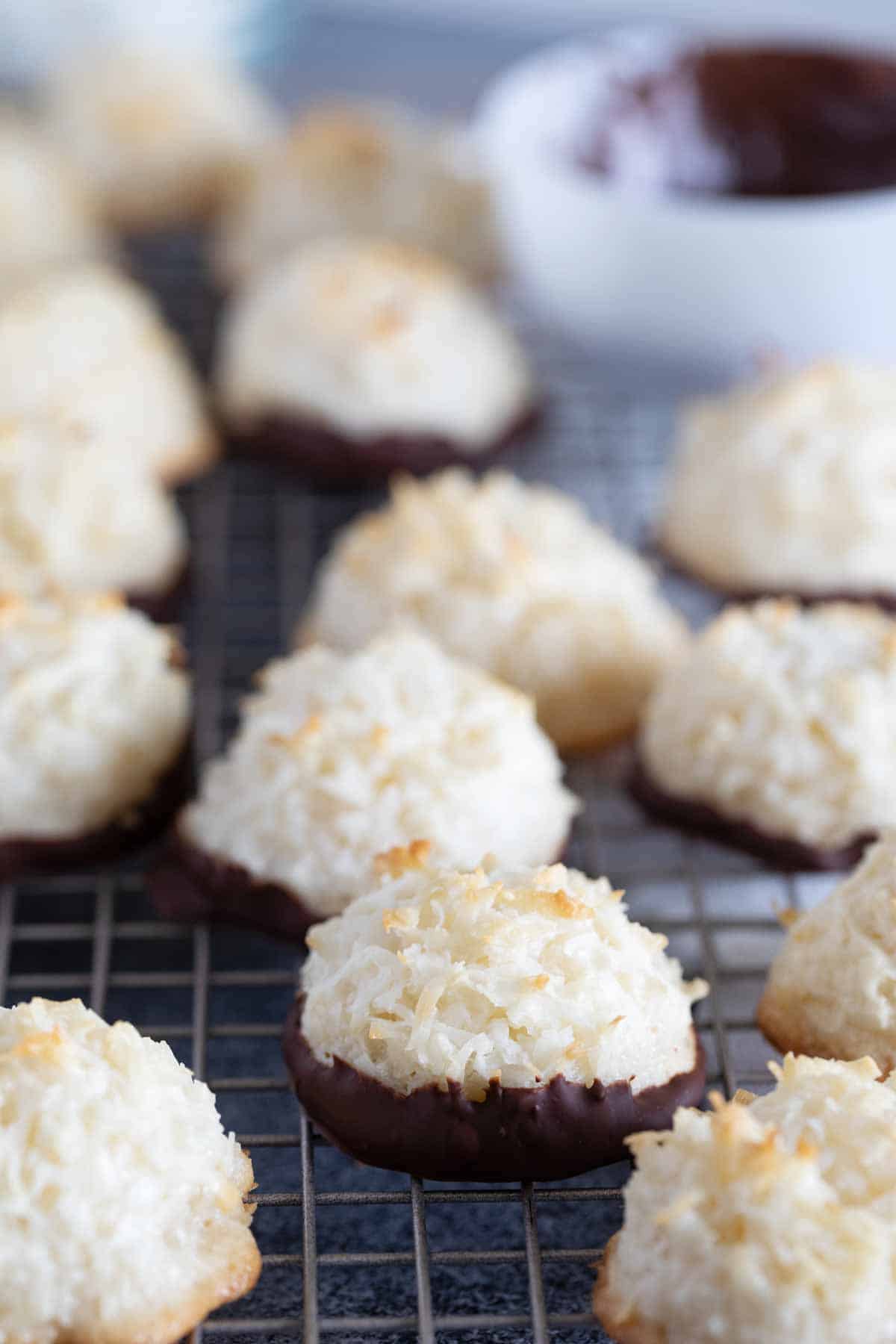 Lightly crispy on the outside and chewy on the inside, these Coconut Macaroons are made for coconut lovers! Dip the bottoms in chocolate for an even more decadent treat. Coconut Macaroons on a cooling rack