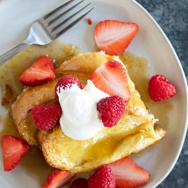 Slices of Creme Brulee French Toast topped with fresh berries.
