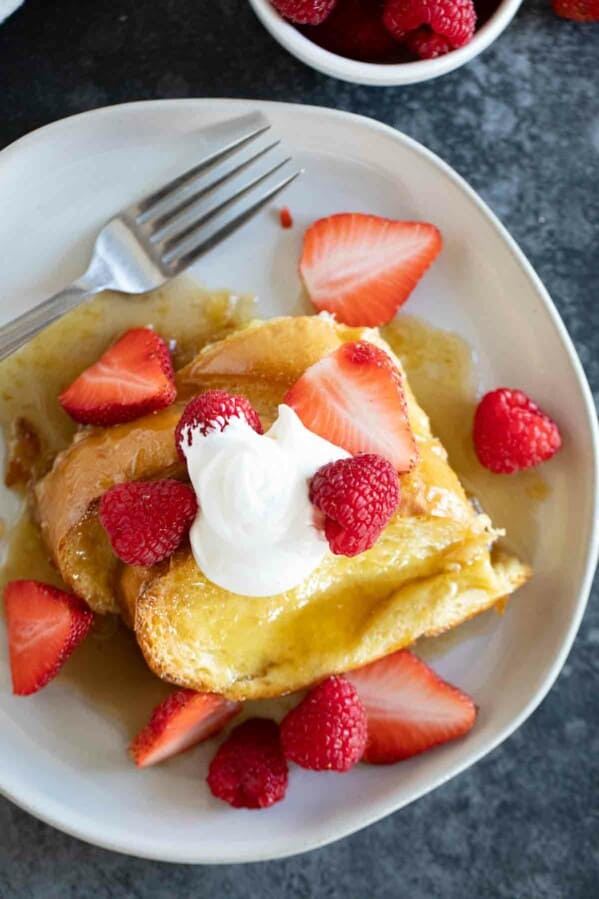 Slices of Creme Brulee French Toast topped with fresh berries.