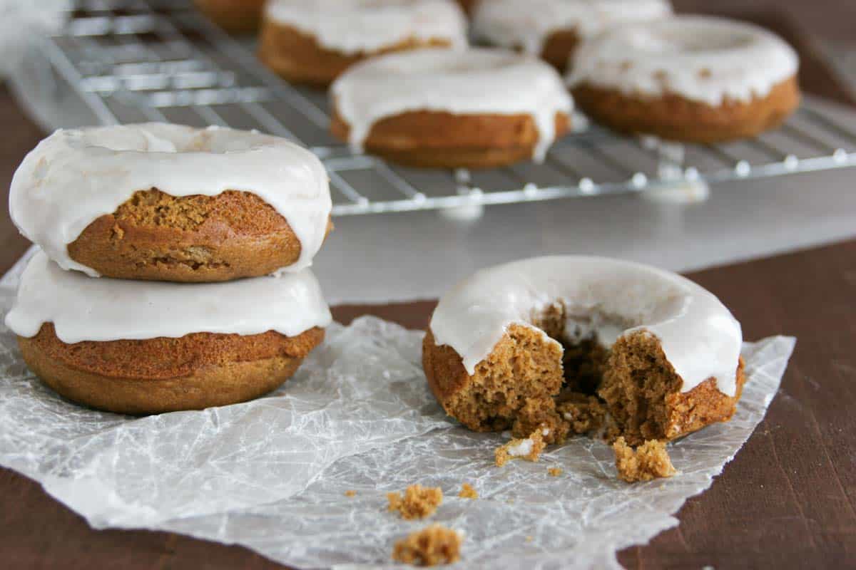 Glazed Gingerbread Baked Donuts with part broken off of one