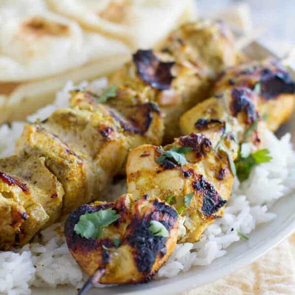 Serving of Grilled Indian Chicken Skewers over rice