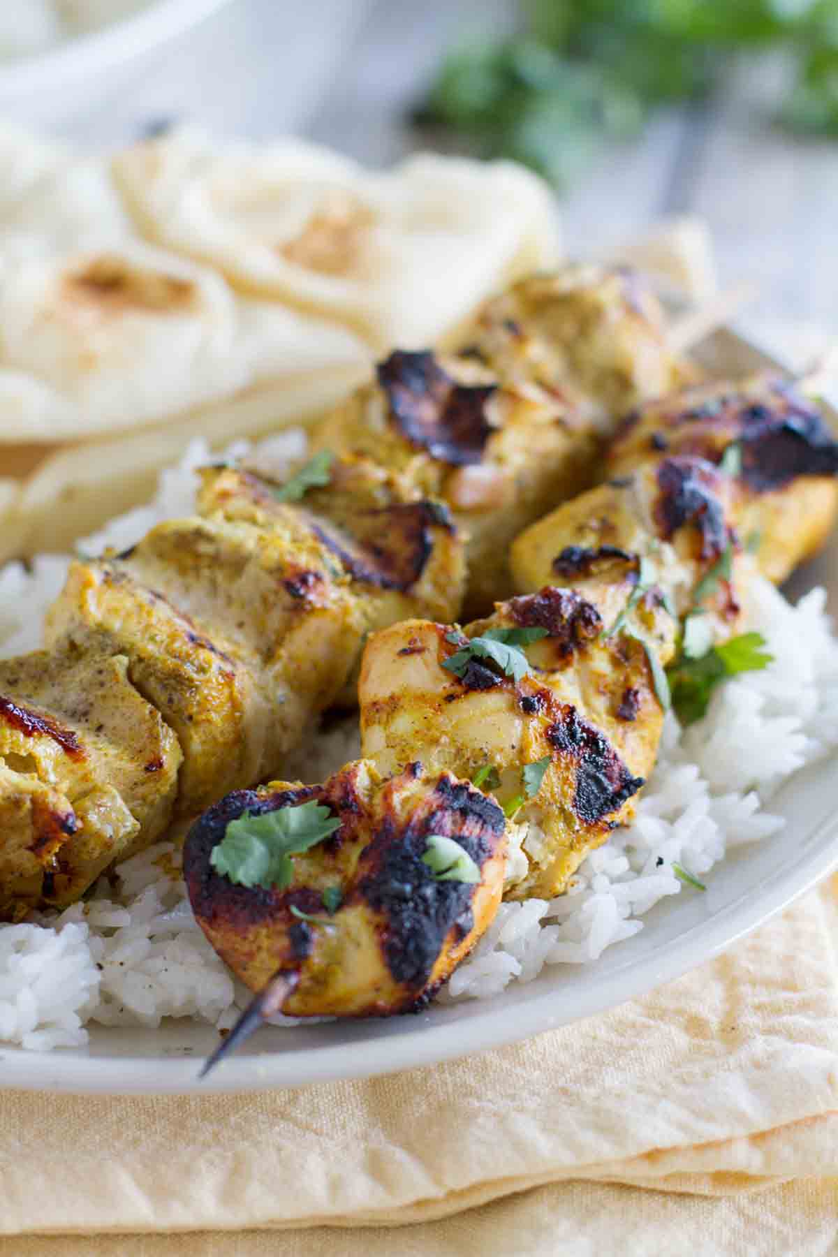 Serving of Grilled Indian Chicken Skewers over rice