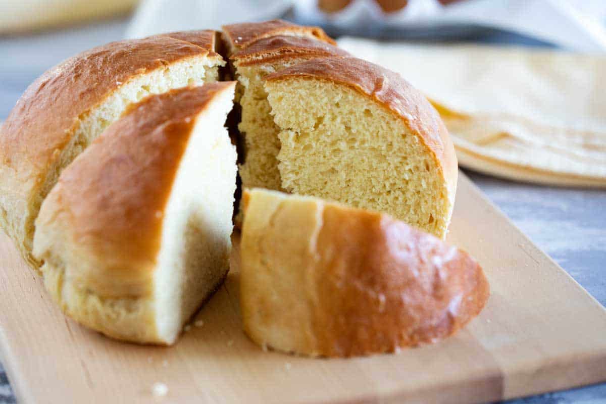 Soft and slightly sweet, this Hawaiian Bread is the perfect side dish to any Hawaiian meal. Serve it up as a side with butter, and save a loaf for French toast the next day! loaf of Hawaiian Bread cut into wedges