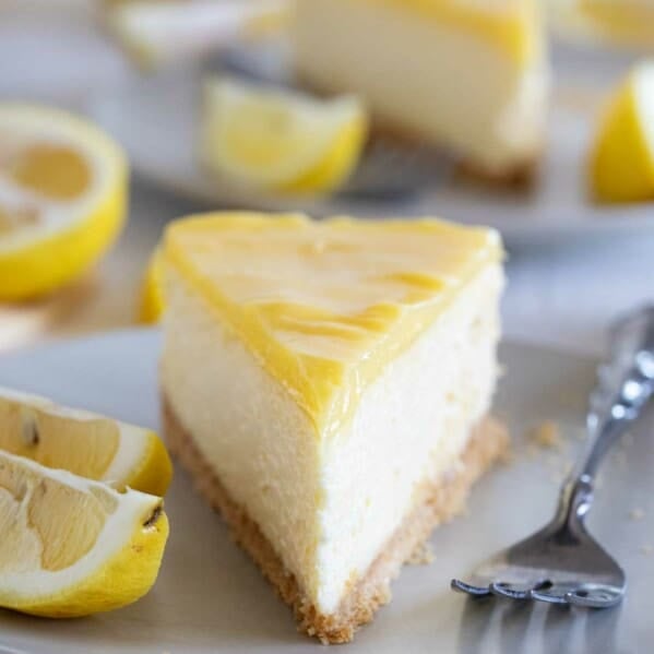 slice of lemon cheesecake with more in the background.