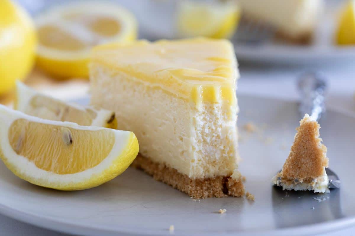 Fork with a bite of lemon cheesecake.