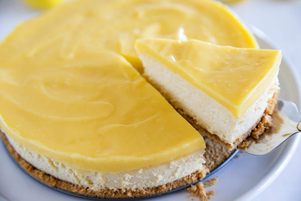 lifting out a slice of lemon cheesecake