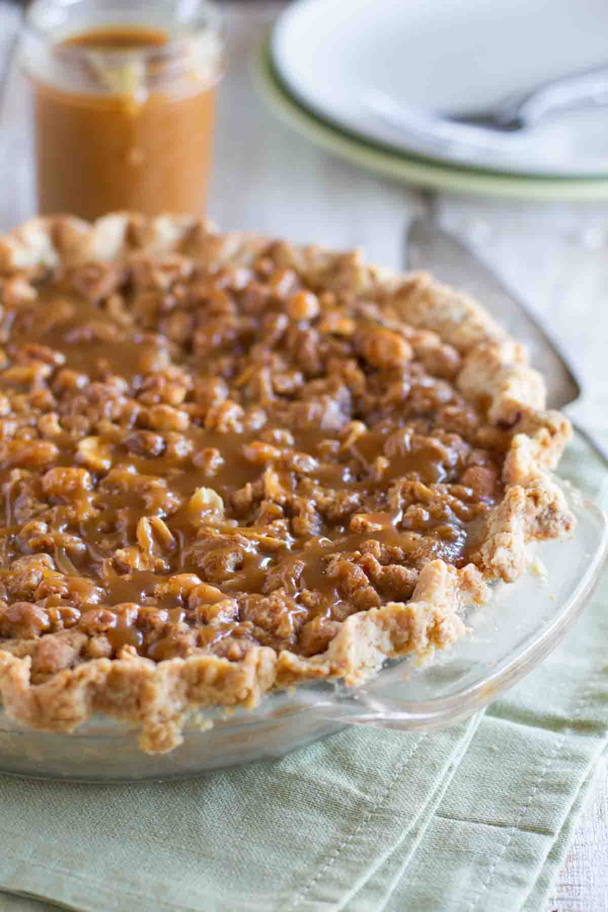 Peanut Butter Fudge Pie topped with salted peanut butter caramel in a pie dish