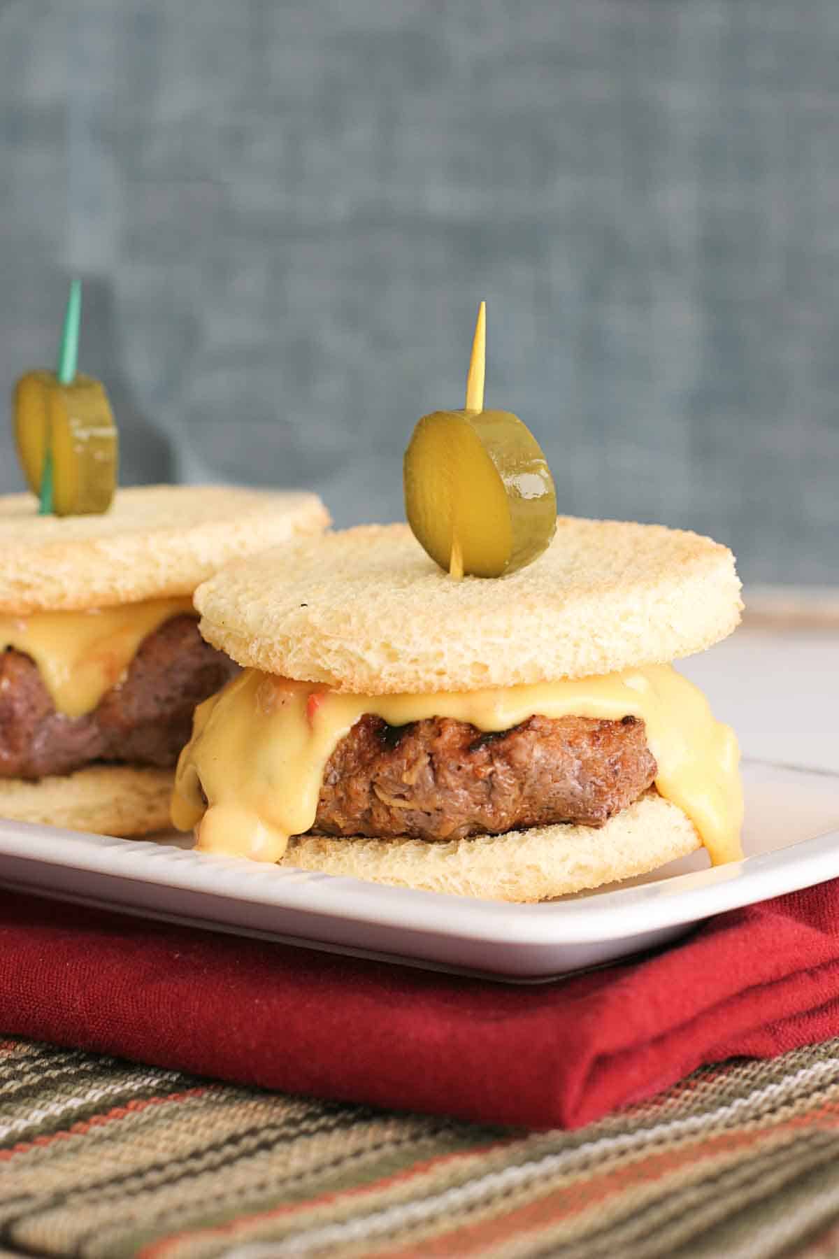 slider sized burgers topped with pimiento cheese and a pickle