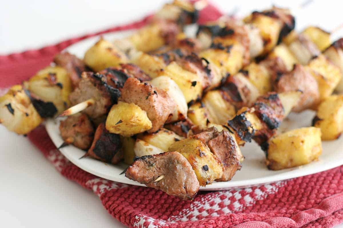 grilled pineapple and pork kabobs on a plate