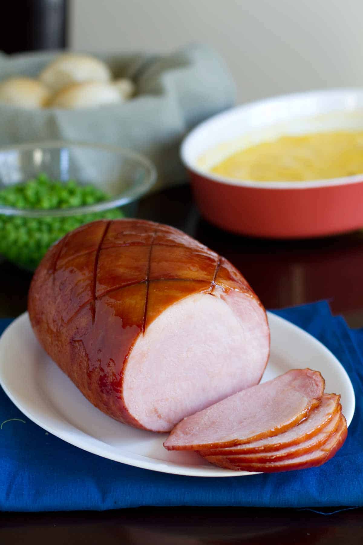 This Root Beer Glazed Ham has a sweet brown sugar and root beer glaze that is baked over a boneless ham for an easy main dish. full Root Beer Glazed Ham partially sliced