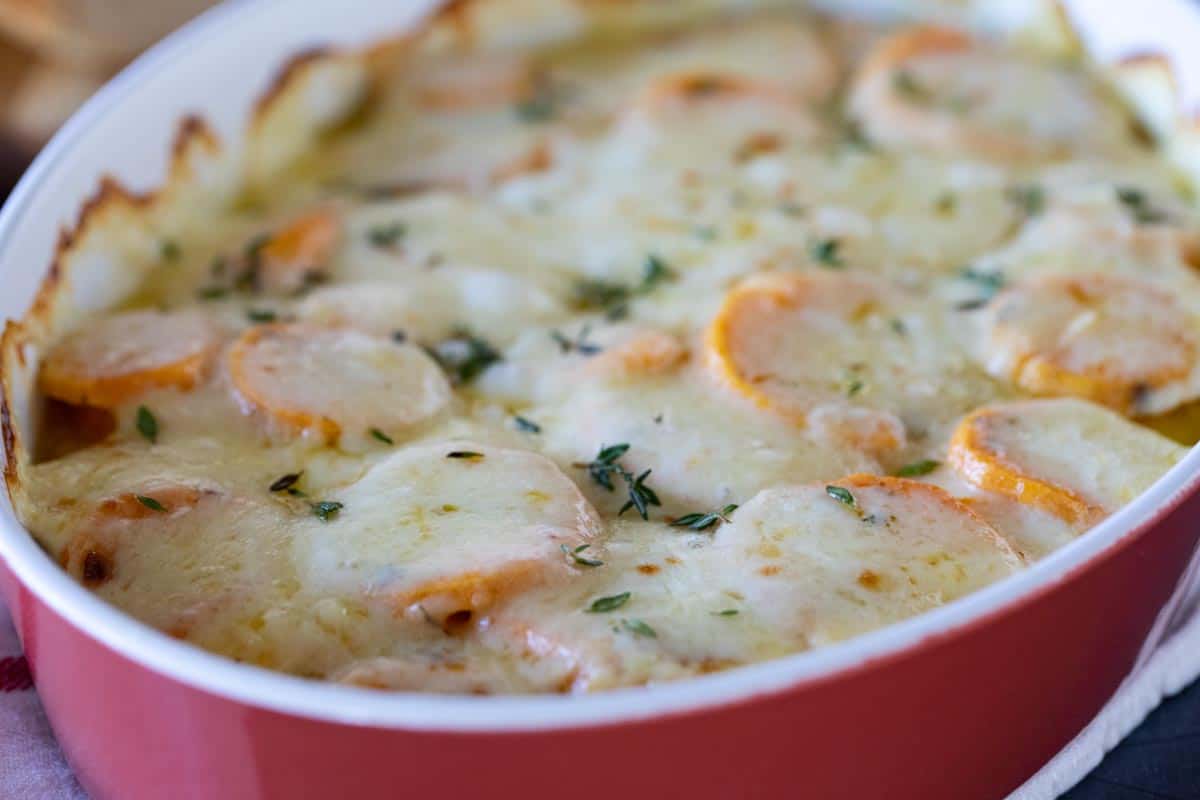 dish of Scalloped Sweet Potatoes topped with cheese and thyme