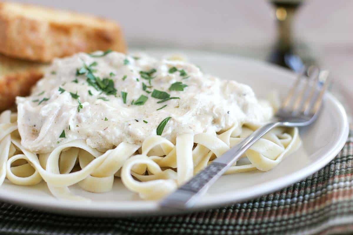 Slow Cooker Chicken Fettuccine on a plate topped with parsley
