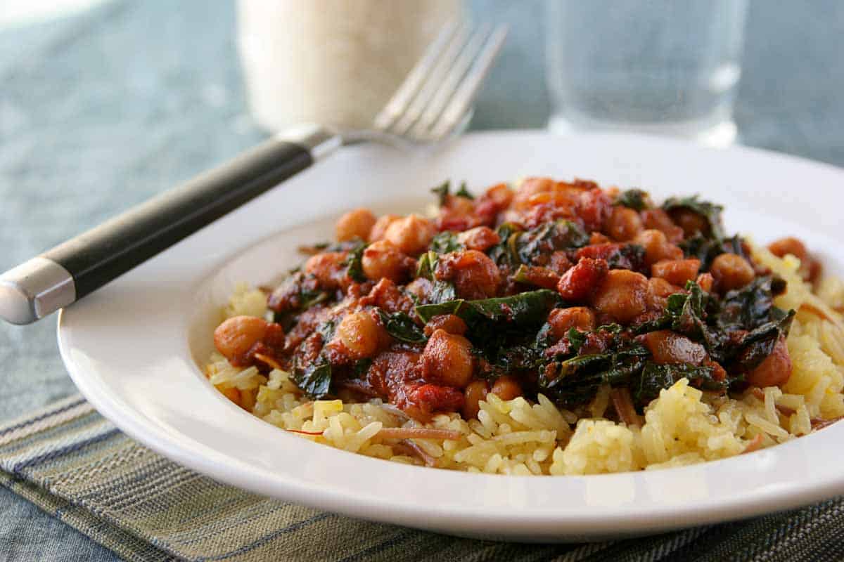 spanish style rice and beans on a plate with a fork