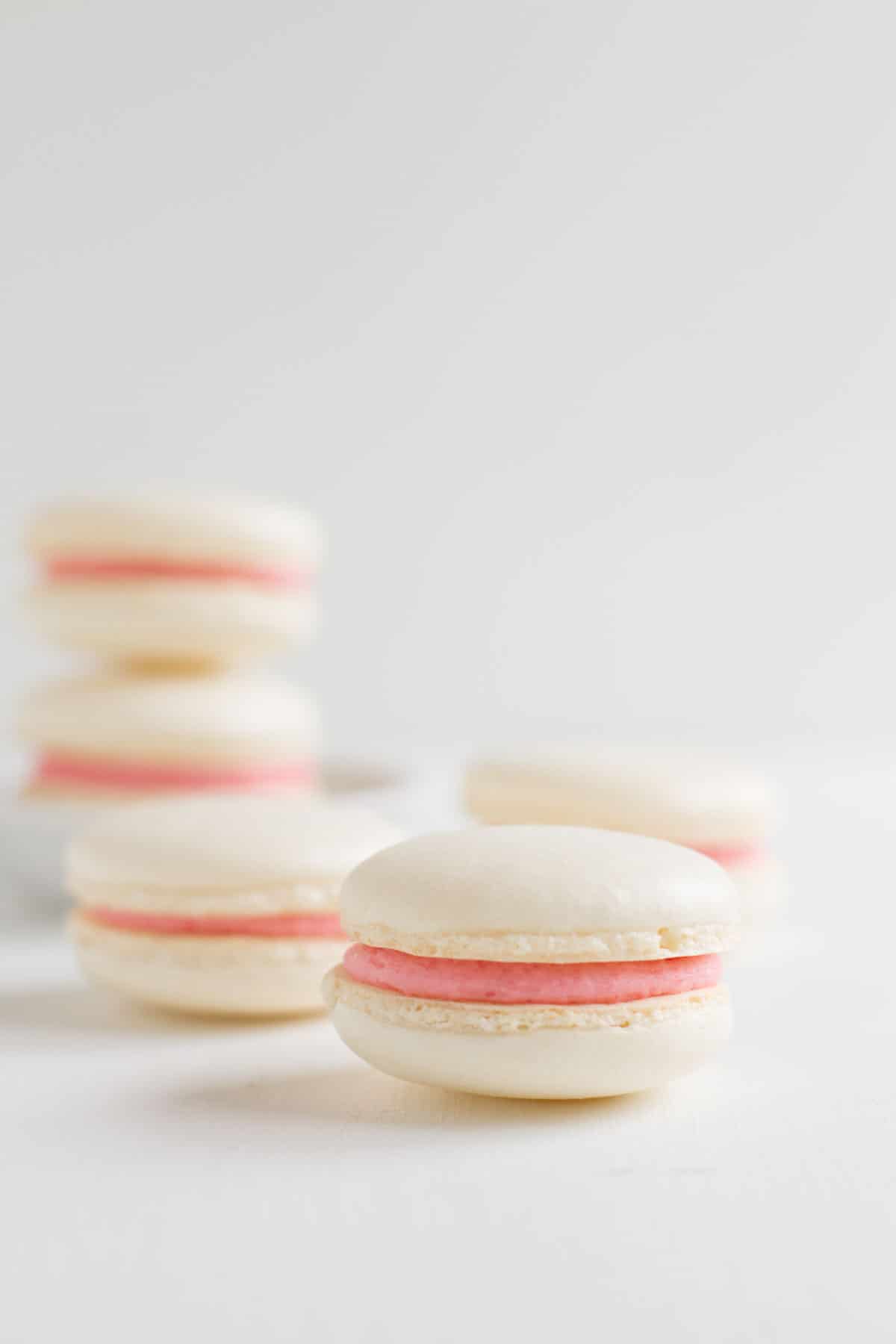 White macaron filled with pink buttercream.