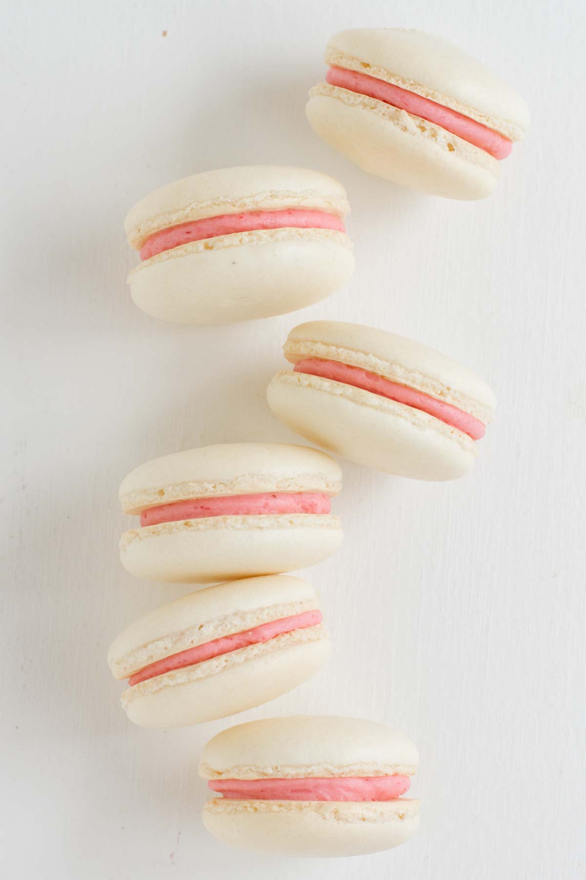 Strawberry Colada Macarons on their sides showing the filling.