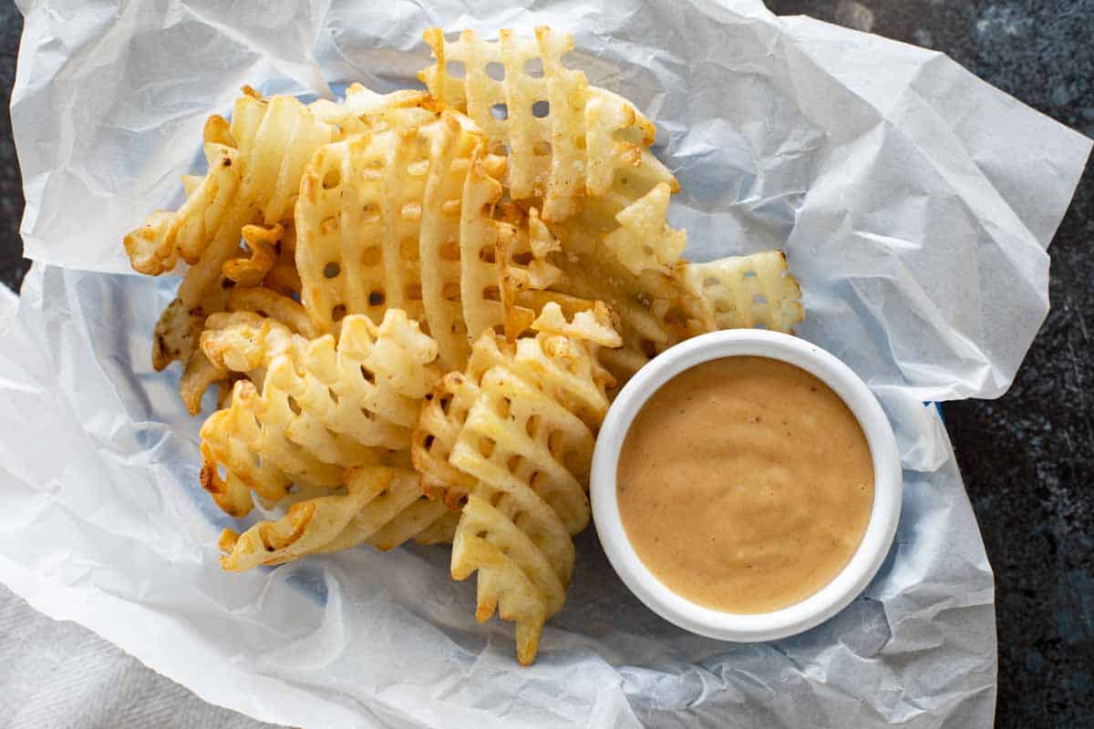 Basket with waffle fries and chick fil a sauce