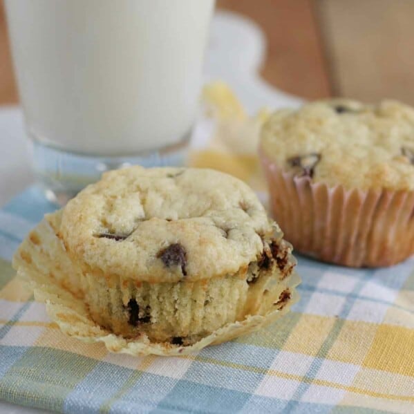 Chocolate Chip Sour Cream Muffins on a towel with the paper liner removed from one.