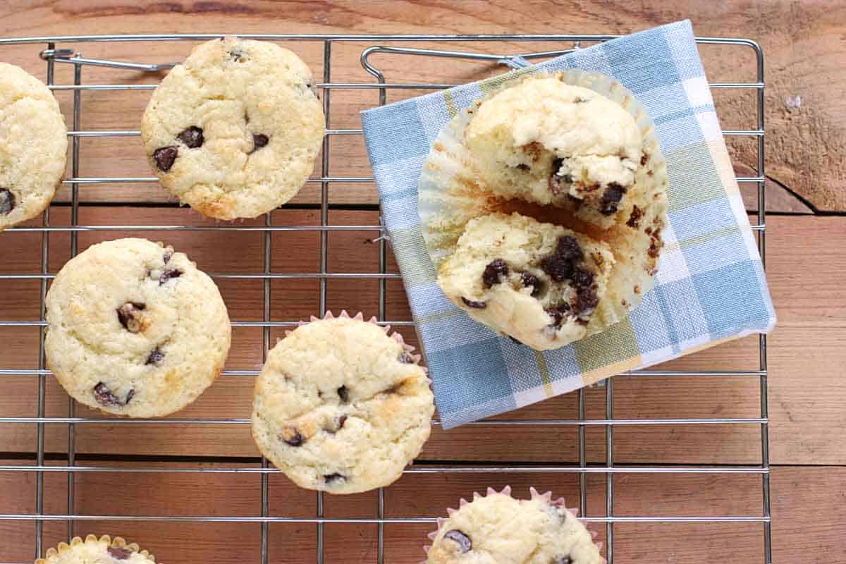 Chocolate Chip Sour Cream Muffins on a cooling rack with one split in half