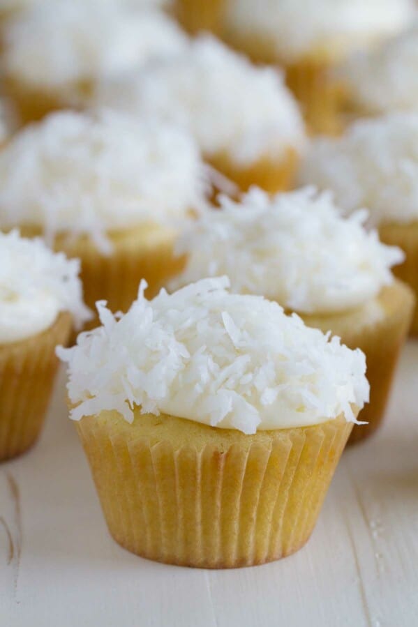 coconut cupcakes topped with cream cheese frosting and coconut