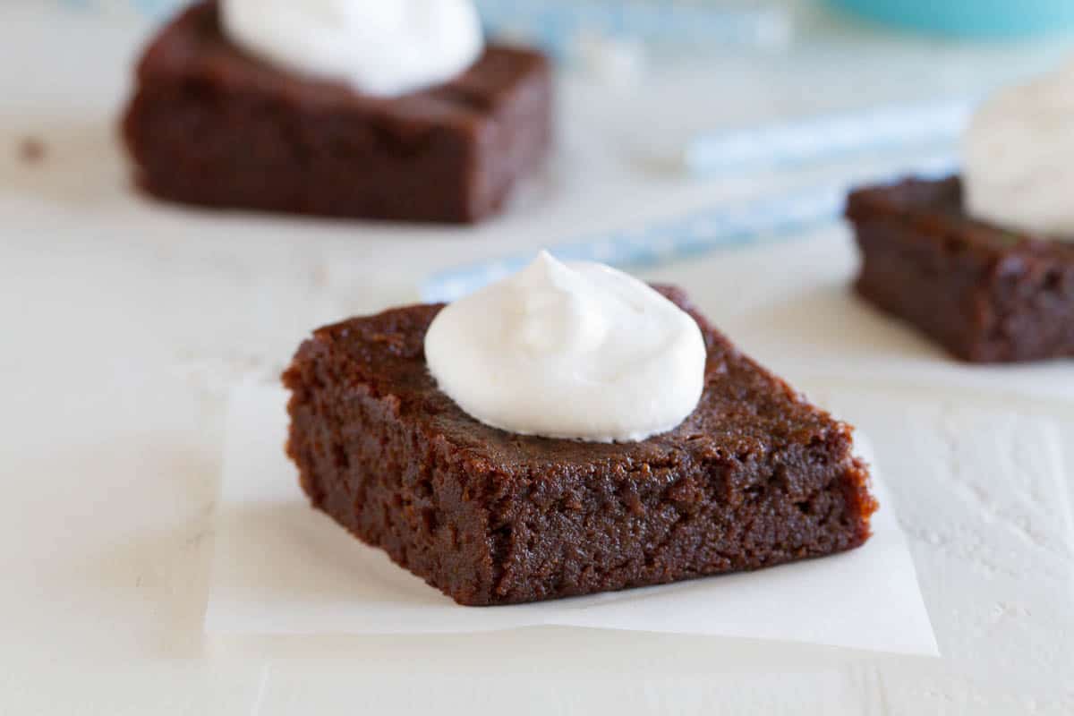 These moist, dense and fudgy Coconut Flour Brownies will convert you even if you aren’t grain free! Dairy free option is also included. coconut flour brownie topped with whipped cream