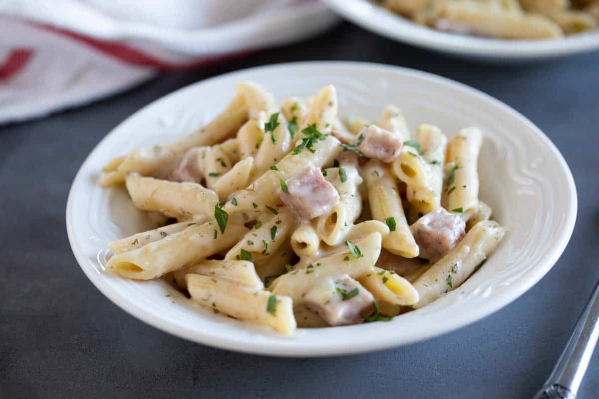 shallow bowl with pasta with ham and ranch sauce