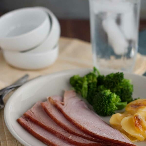 slices of Honey Glazed Ham on a plate with potatoes and broccoli