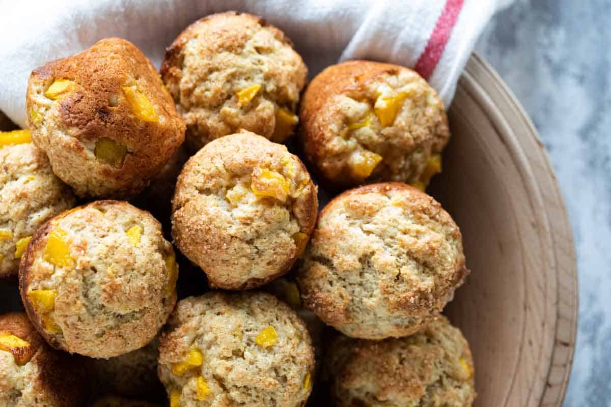 wooden bowl filled with mango muffins with banana