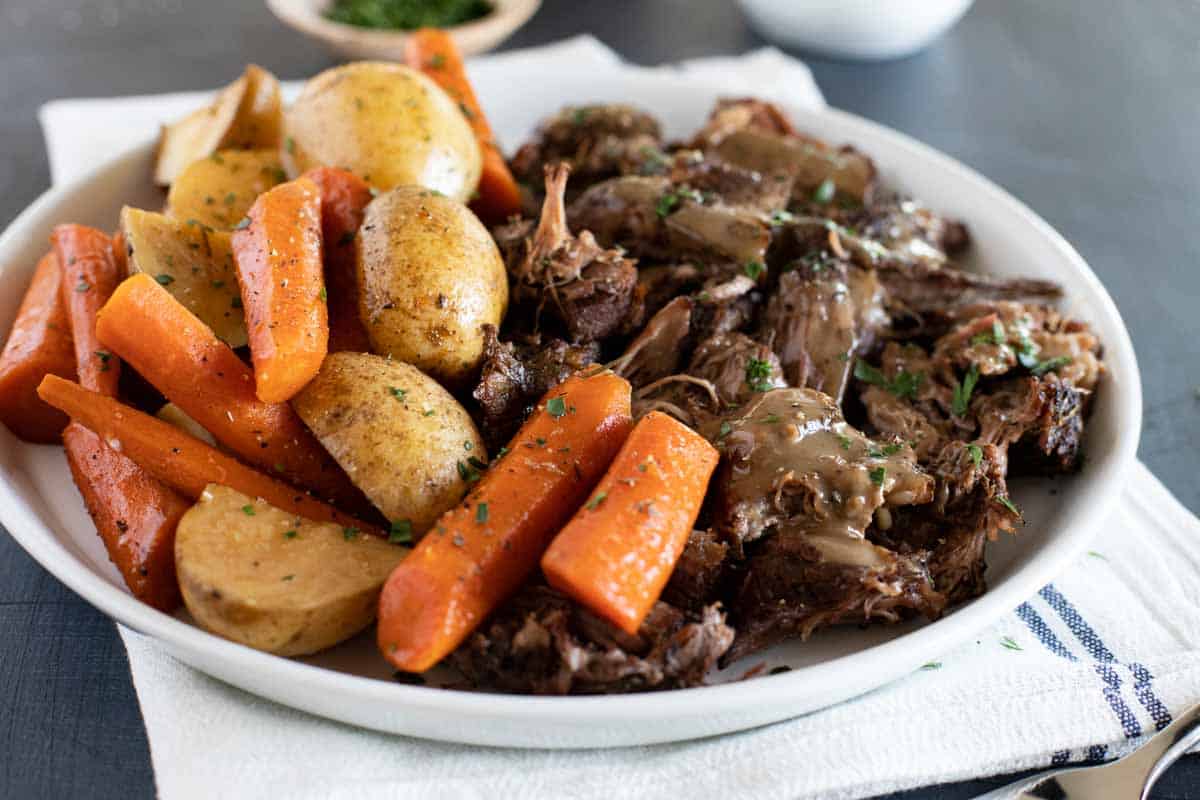 Slow Cooker Pot Roast on a plate with carrots and potatoes