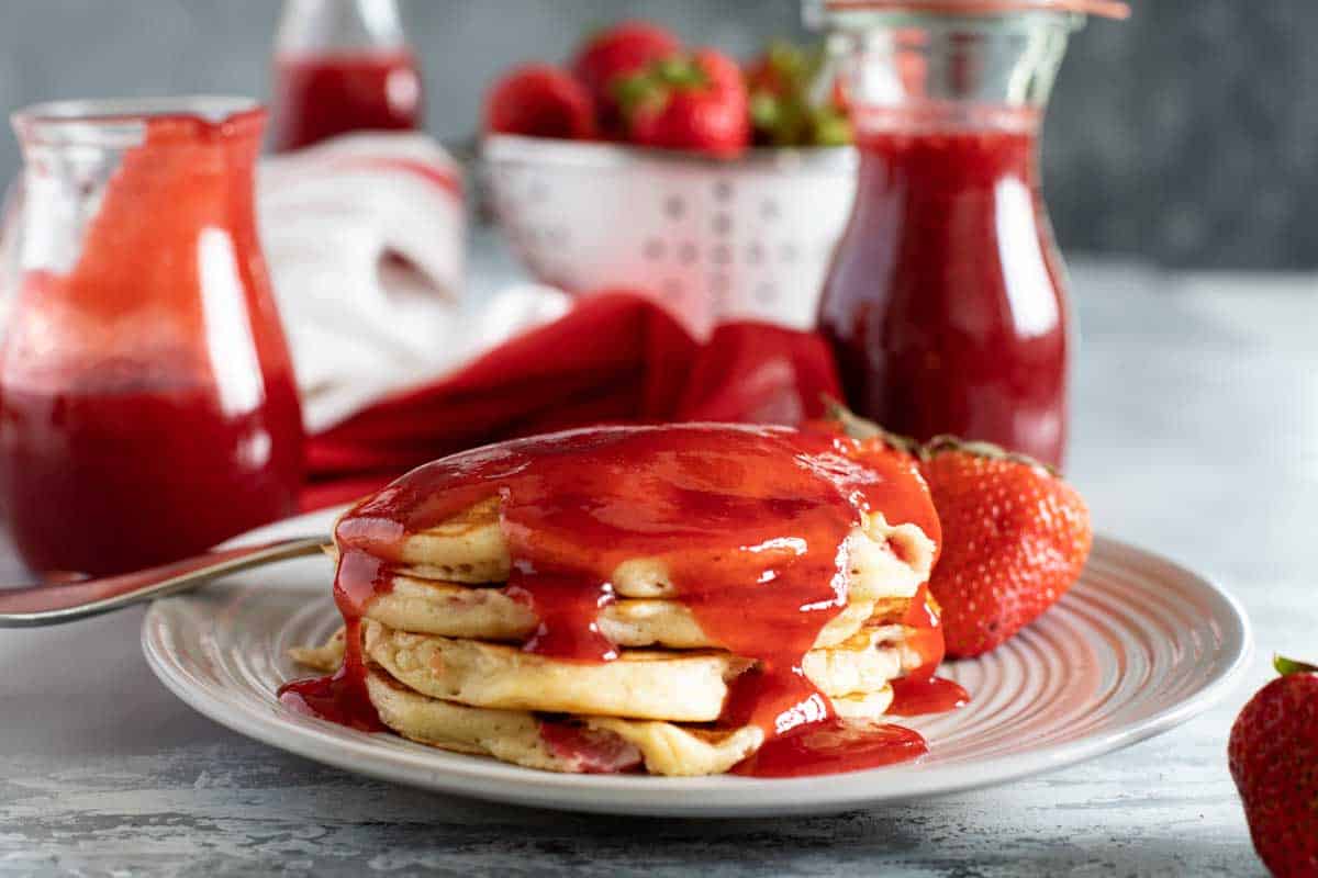 Strawberry Pancakes on a plate with strawberry syrup