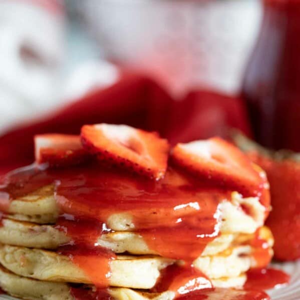 stack of Strawberry Pancakes with strawberry syrup and fresh berries
