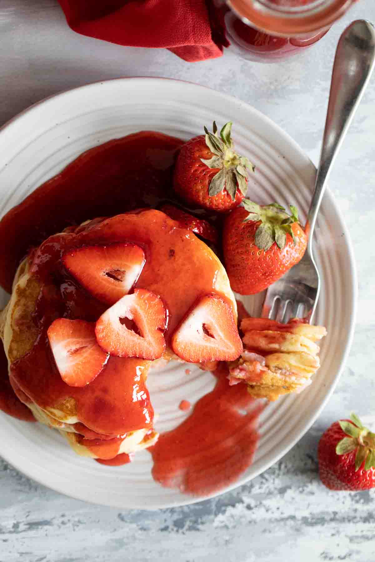 Strawberry Pancakes with a forkful taken from the stack