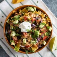 Taco Salad topped with lots of toppings and tortilla chips