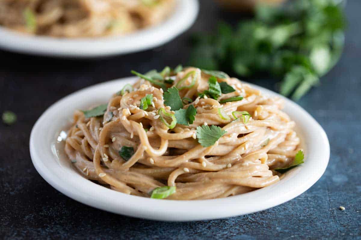 plate of Thai Peanut Noodles topped with cilantro and sesame seeds.