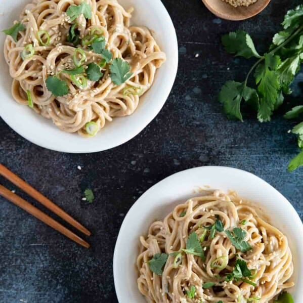 two plates with Thai Peanut Noodles topped with cilantro