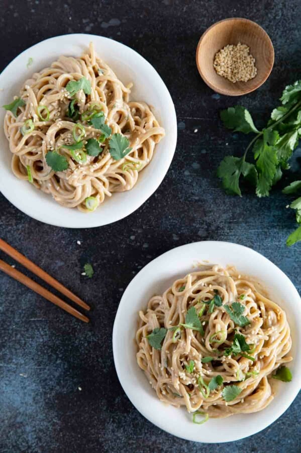 two plates with Thai Peanut Noodles topped with cilantro
