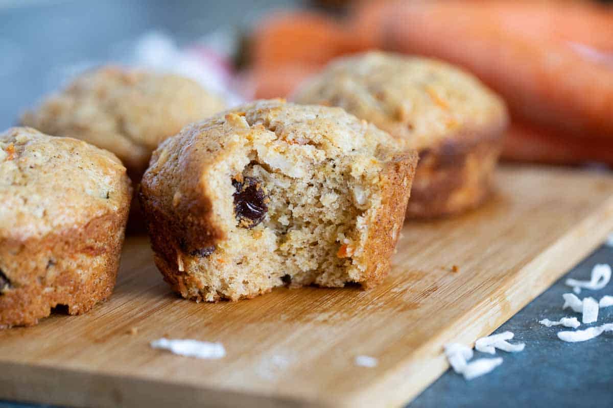 Carrot muffin with a bite taken from it.