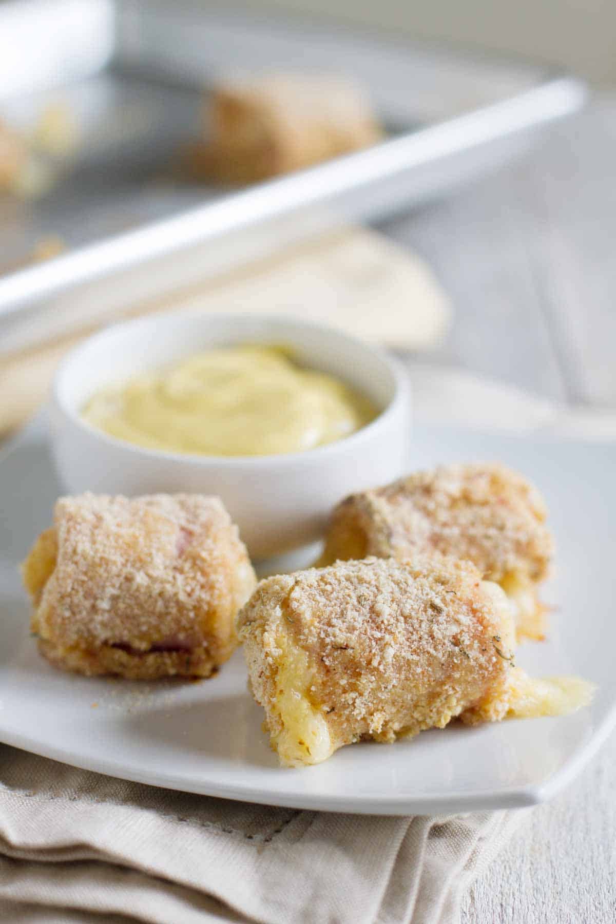 These Chicken Cordon Bleu Nuggets have chunks of chicken that are wrapped in ham and swiss and covered in a breadcrumb coating for a fun appetizer or family friendly dinner. Three Chicken Cordon Bleu Nuggets with dipping sauce