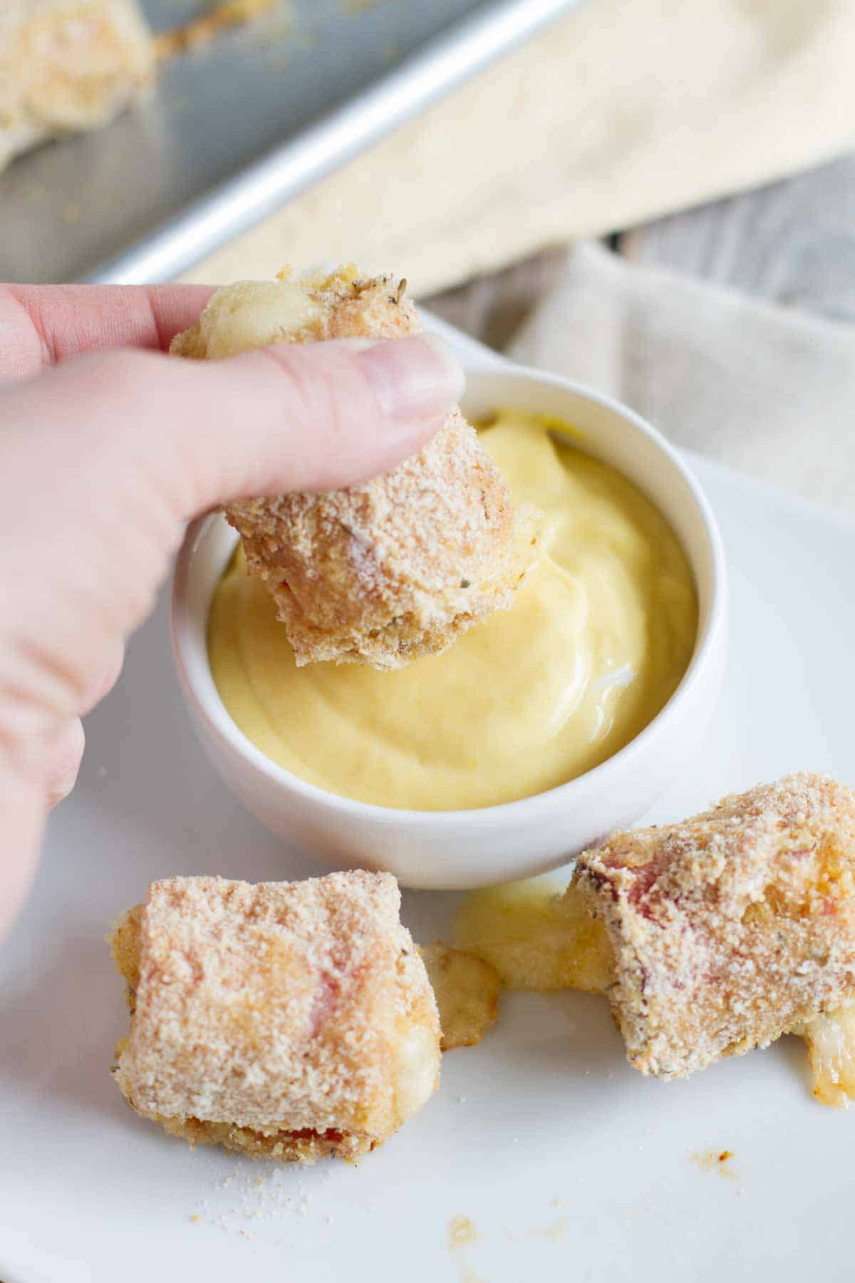 dipping chicken cordon bleu nuggets into honey mustard sauce