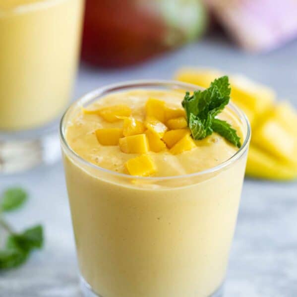 glass of fresh fruit batido topped with fresh mango