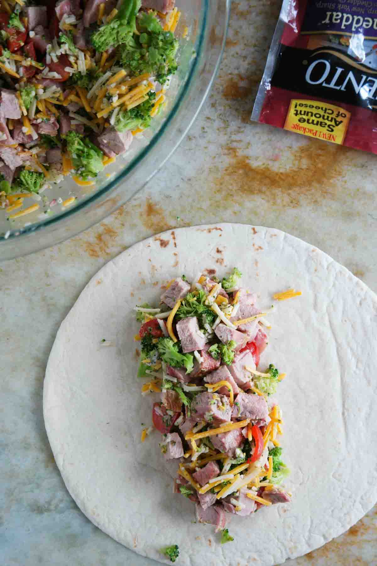 putting filling on a tortilla for Grilled Pork Burritos