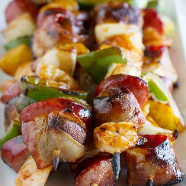 Grilled Shrimp and Sausage Kabobs stacked on a plate