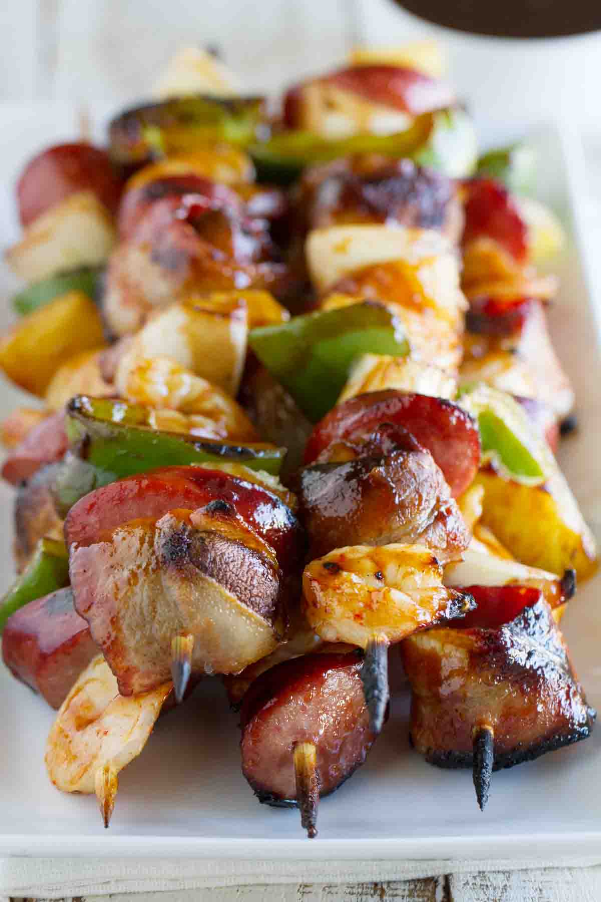 Grilled Shrimp and Sausage Kabobs stacked on a plate