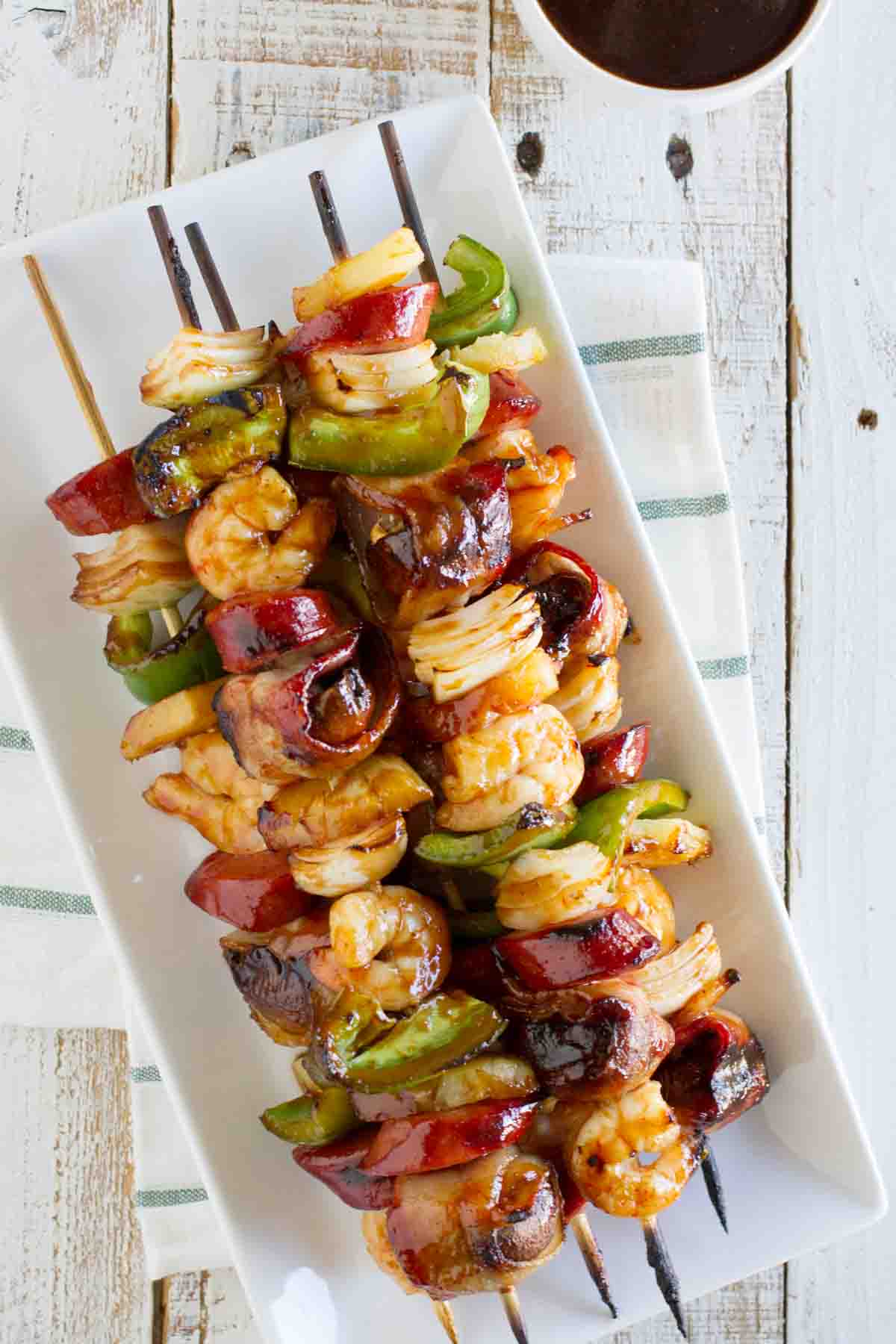 I know I have it easy today, because well - central air. I know I really have no ground to stand on when it comes to complaints, because there are areas of the country where central air isn't pretty much standard. But still - the heat zaps all of the energy and motivation right out of me. stack of grilled shrimp and sausage kabobs